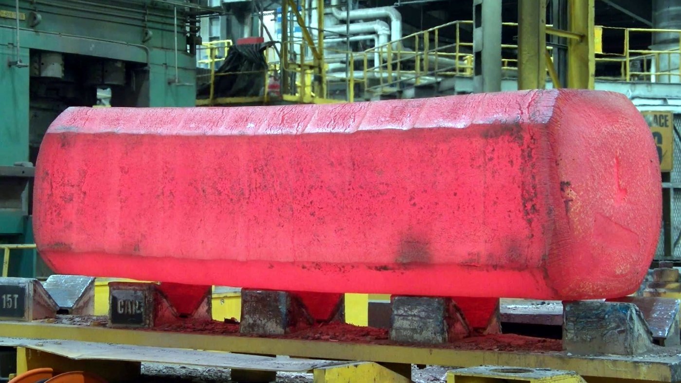 Photograph of a hot billet with a translucent red segmentation mask over it; the background and cradles are unmasked.